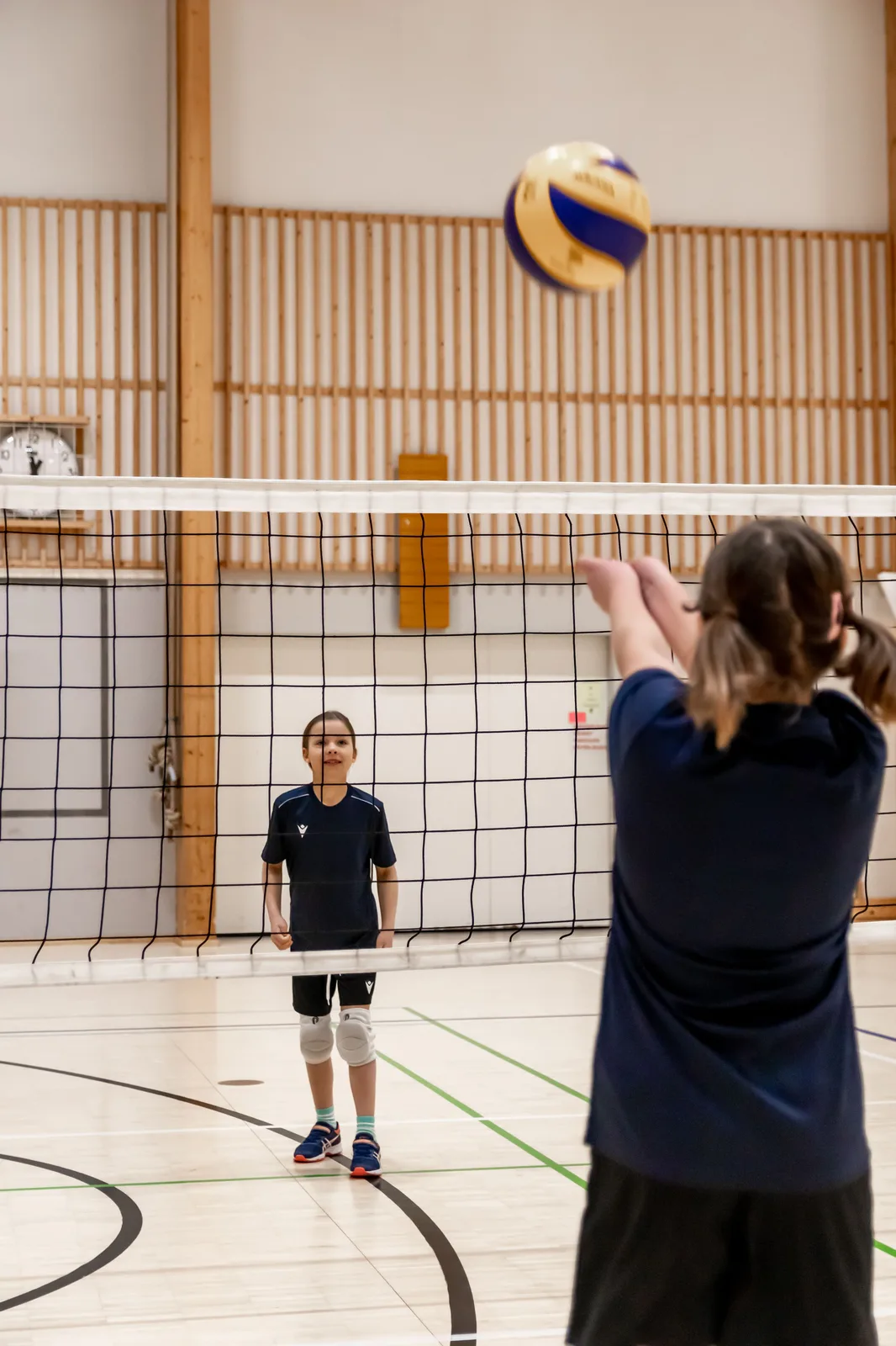 Kaksi junioripelaajaa harjoittelemassa verkon ääressä